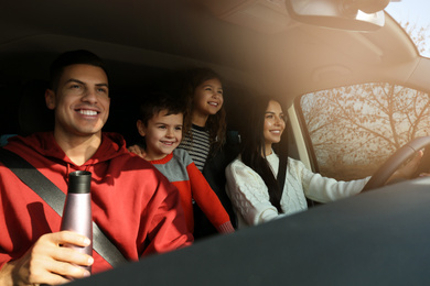 Happy family with little children inside modern car