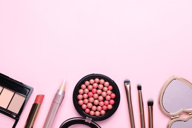 Flat lay composition with makeup products on pink background, space for text