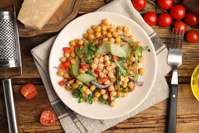 Delicious fresh chickpea salad served on wooden table, flat lay
