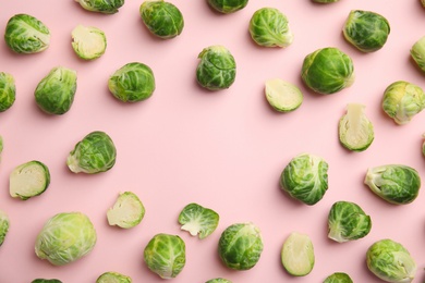Fresh Brussels sprouts on pink background, flat lay. Space for text