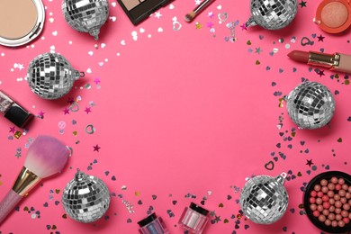 Frame of shiny disco balls and cosmetic products on pink background, flat lay. Space for text