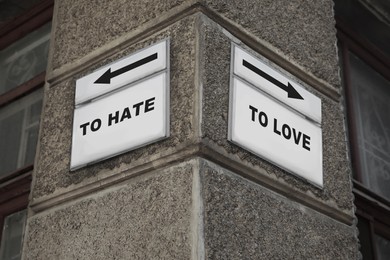 Sign boards with different directions - TO HATE or TO LOVE on building outdoors