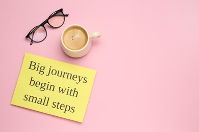 Motivational quote Big journeys begin with small steps, cup of coffee and glasses on pink background, flat lay. Space for text