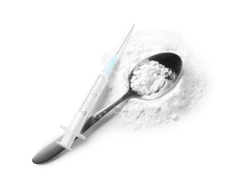 Spoon with cocaine and empty syringe on white background, top view