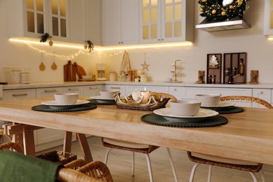 Table with dishware in beautiful kitchen decorated for Christmas. Interior design
