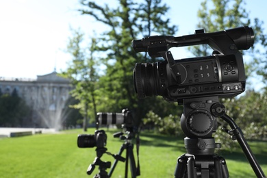 Modern video cameras in park. Professional media equipment