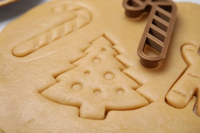 Photo of Christmas treat. Cookie cutter and dough on table, closeup