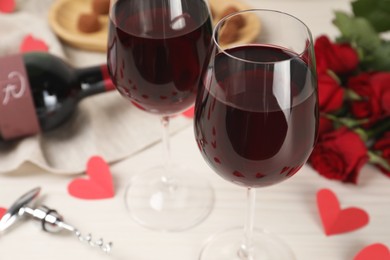 Photo of Glasses of red wine on white table, closeup