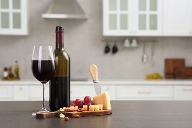 Photo of Red wine with fruits and, nuts, grape and cheese on countertop in kitchen, space for text