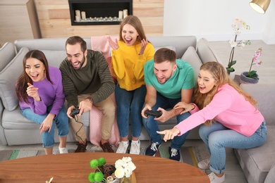 Group of friends engaged in video game indoors. Celebrating victory