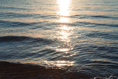 Rippled surface of sea at sunset as background
