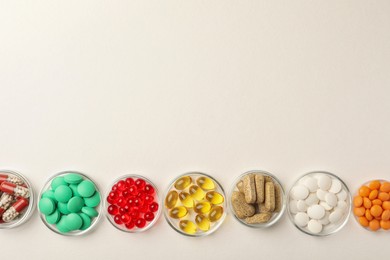 Different dietary supplements in bowls on white background, flat lay. Space for text