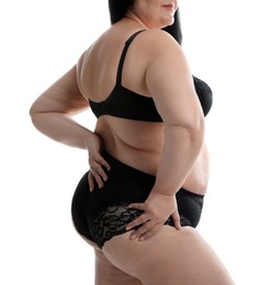 Overweight woman in black underwear on white background, closeup. Plus-size model