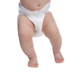 Cute baby in dry soft diaper standing on white background, closeup