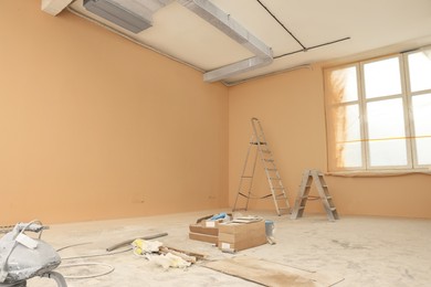 Photo of Room with pale orange walls and windows prepared for renovation