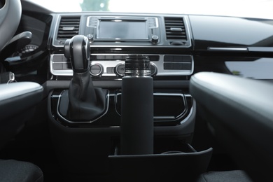 Black thermos in holder inside of car