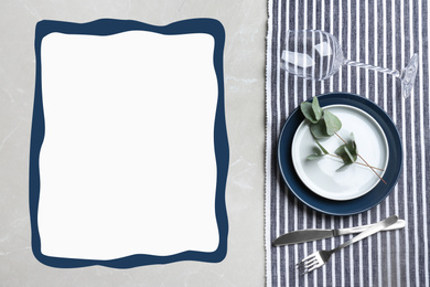 Elegant table setting and empty menu on grey marble table, flat lay. Space for text