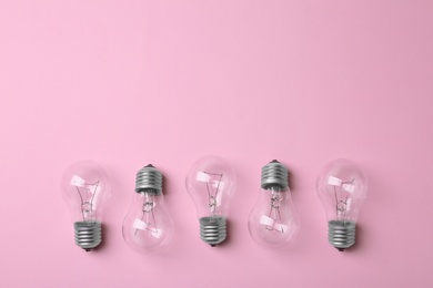 New incandescent lamp bulbs on pink background, top view. Space for text