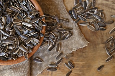 Photo of Organic sunflower seeds on wooden table, flat lay