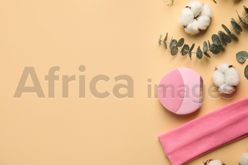 Photo of Flat lay composition with face cleansing brush on beige background. Cosmetic accessory