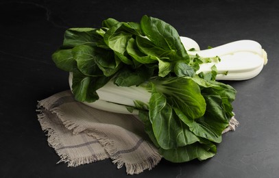 Fresh green pak choy cabbages on black table