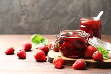 Delicious pickled strawberry jam and fresh berries on wooden table. Space for text