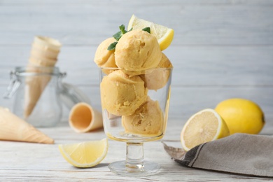 Yummy lemon ice cream served on white wooden table