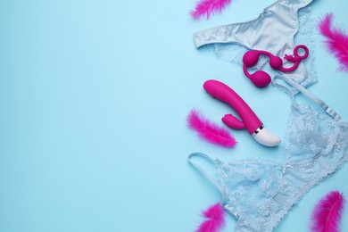 Sex toys, feathers and lingerie on light blue background, flat lay. Space for text