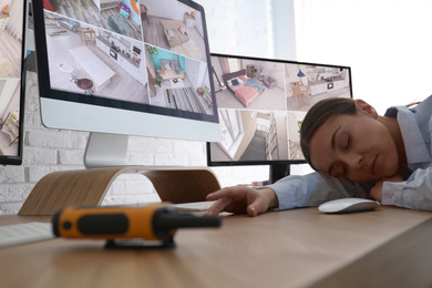 Female security guard sleeping near monitors at workplace