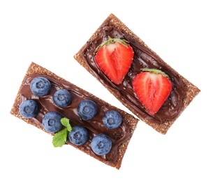 Photo of Fresh crunchy rye crispbreads with chocolate spread and sweet berries isolated on white, top view
