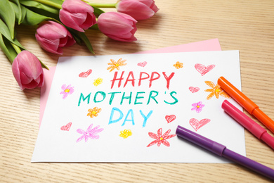 Greeting card for Mother's day, felt tip pens and tulips on wooden background