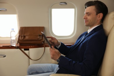 Businessman working on tablet in airplane during flight