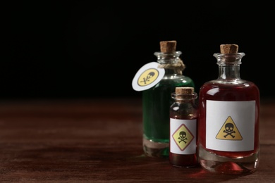 Bottles with poisons on wooden table. Space for text