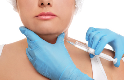 Woman with double chin getting injection on white background, closeup. Cosmetic surgery