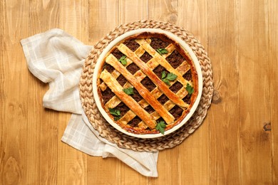 Photo of Freshly baked meat pie on wooden table, top view