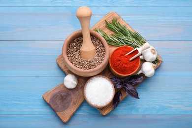 Photo of Flat lay composition with mortar and different spices on light blue wooden table