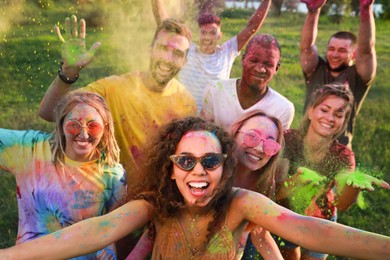 Happy friends covered with colorful powder dyes outdoors. Holi festival celebration