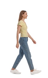 Photo of Young woman in casual outfit walking on white background