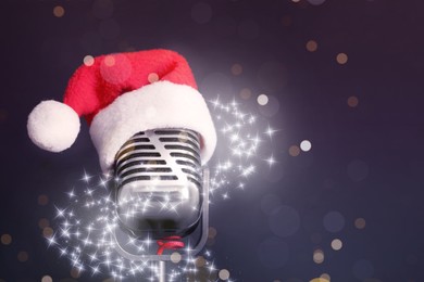 Retro microphone with Santa hat on dark background, space for text. Christmas music