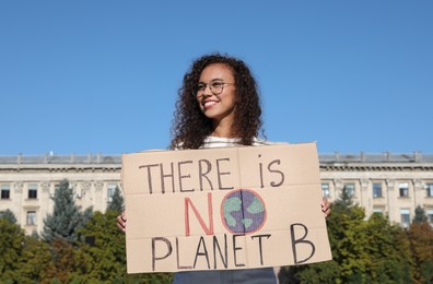 African American young woman with poster protesting against climate change outdoors