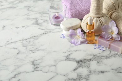 Spa composition with skin care products on white marble table. Space for text