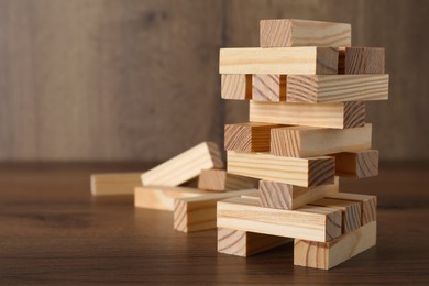 Jenga tower and wooden blocks on table, space for text
