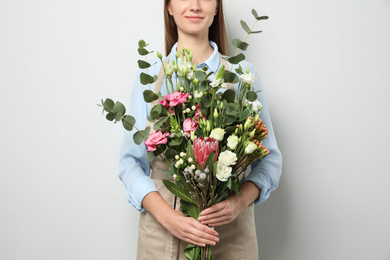Florist with beautiful bouquet on light background, closeup
