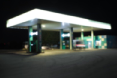Blurred view of modern gas station with convenience store beside the road at night