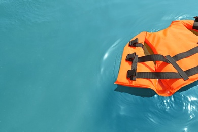Orange life jacket floating in sea. Emergency rescue equipment