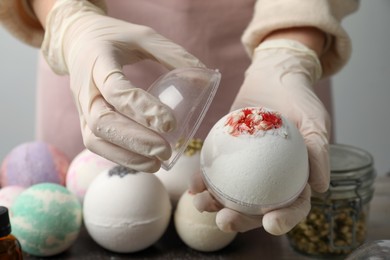 Woman in gloves with self made bath bomb at table, closeup