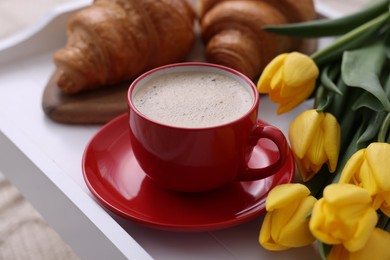 Morning coffee, flowers and croissants on white wooden tray, closeup