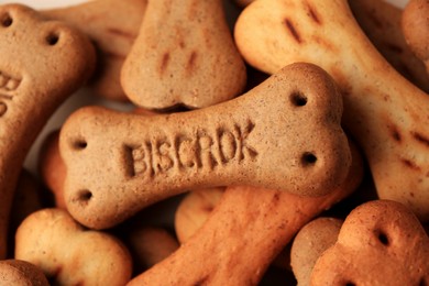Photo of Heap of bone shaped dog cookies as background, closeup