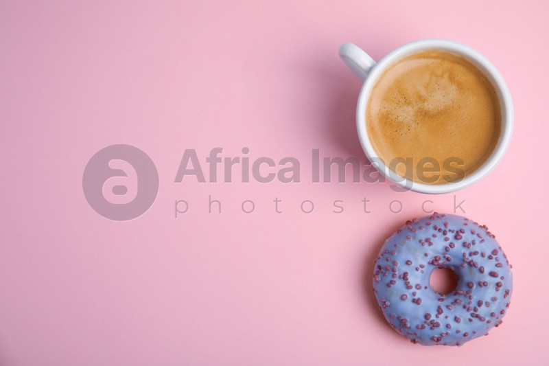 Photo of Delicious coffee and donut on light pink background, top view with space for text. Sweet pastries
