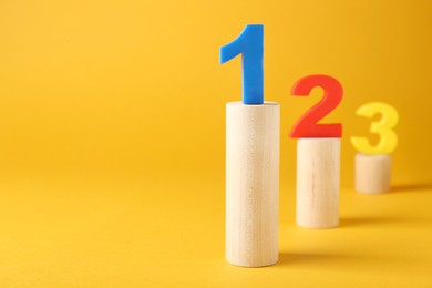 Photo of Numbers on wooden blocks against pale orange background, space for text. Competition concept